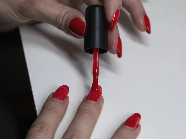 Aplicar esmalte de uñas de gel rojo en las uñas de las mujeres —  Fotos de Stock