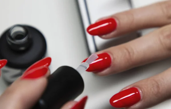 Applying red gel nail polish on women's nails — Stock Photo, Image