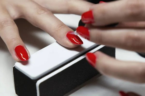 Aplicar esmalte de uñas de gel rojo en las uñas de las mujeres —  Fotos de Stock