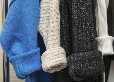 Sıcak renkli örgü süveterler ahşap tremplere asılır.
