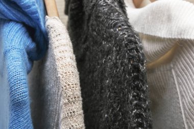 Sıcak renkli örgü süveterler ahşap tremplere asılır.