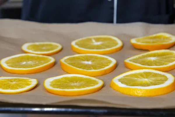 Kurutmak için dilimlenmiş taze portakal halkaları.