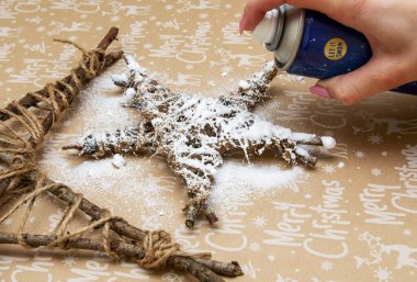 spray artificial snow on a makeshift Christmas toy clipart