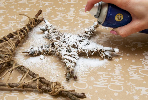 Besproei kunstmatige sneeuw op een geïmproviseerd kerstspeelgoed — Stockfoto
