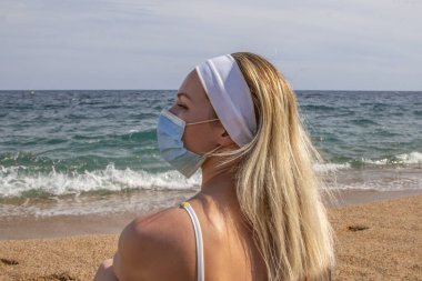 Plajda maske takmış güzel bir kız.