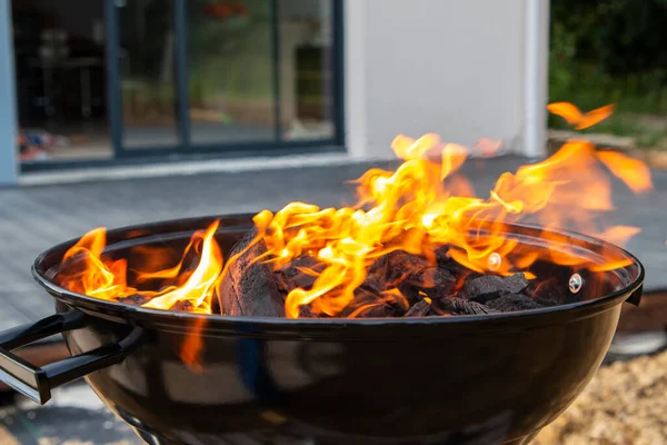 Dışarıda kömür yanan siyah bir barbekü, ateş.