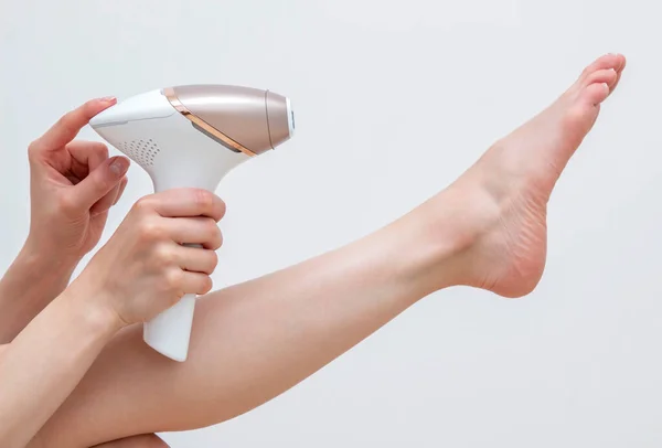 Bacak foto epilasyon prosedürü uygulayan bir kadın.