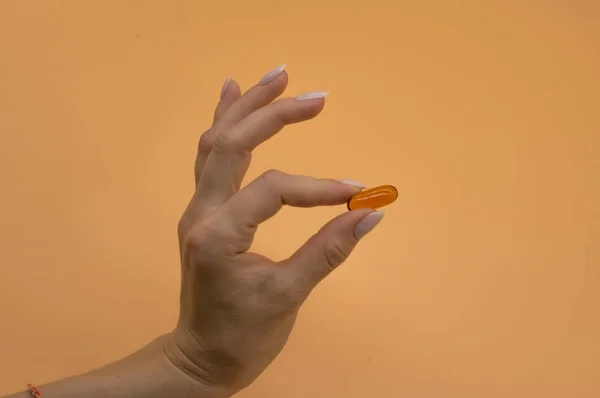 Красивые руки с кучей витаминов на оранжевом фоне — стоковое фото
