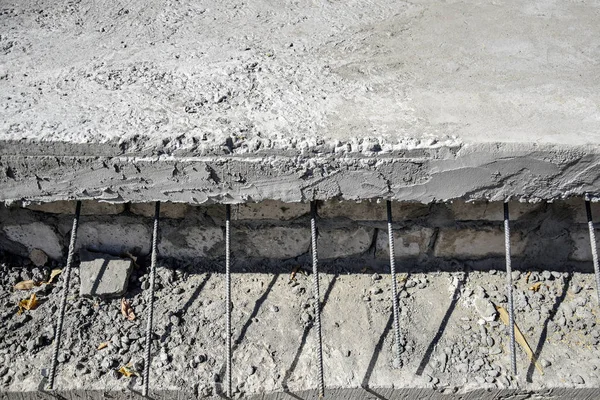 Concrete slab with protruding reinforcing metal rods. Metal fittings for concrete pouring. The technology of building floors. Close-up. Selective focus. Copy space.
