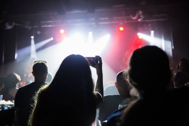 Kalabalık konser ve bulanık sahne ışıkları. Smartphone ile bir konser sırasında fotoğraf çekmek yakın çekim .