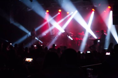 Kalabalık konser ve bulanık sahne ışıkları. Smartphone ile bir konser sırasında fotoğraf çekmek yakın çekim .