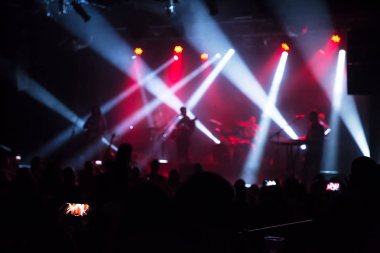 Konserde kalabalık ve bulanık sahne ışıkları .