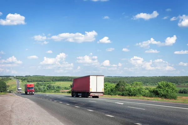 Trucks and cars drive along the summer road, the highway. — Stock Photo, Image