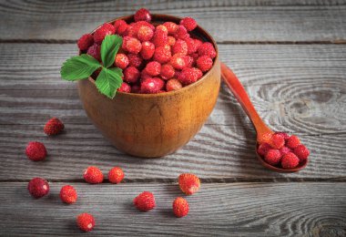 Tahta bir fincanda, tahta bir arka planda böğürtlen.