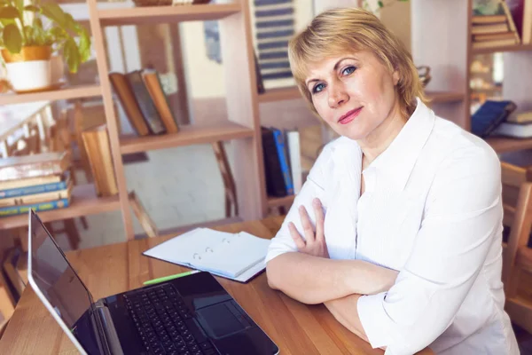 Uma mulher adulta trabalhando em um laptop no escritório — Fotografia de Stock