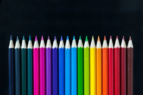 Colored pencils on the table in different combinations and proportions