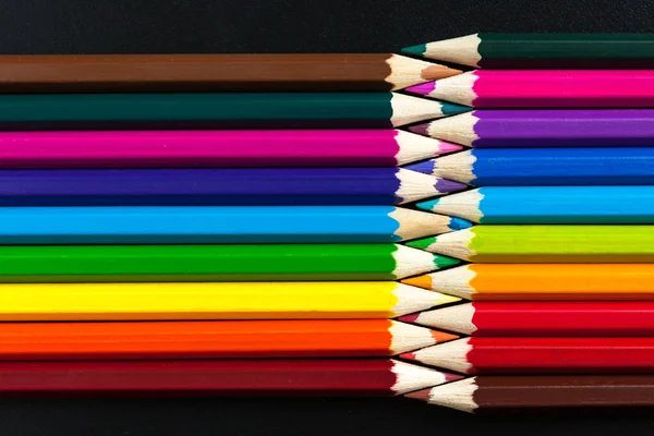 Colored pencils on the table in different combinations and proportions