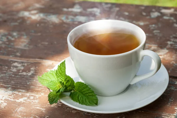 Uma xícara de chá em uma mesa de madeira. — Fotografia de Stock