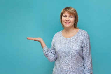 Mavi arka planda gömlek ve kot giyen Noel kadını