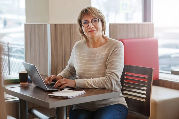Kvinna i café och kontor arbetar med bärbar dator — Stockfoto