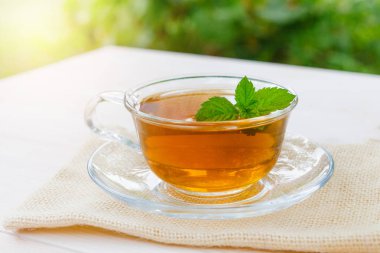 Bir fincan çay, doğadaki ahşap bir masanın üzerinde. .