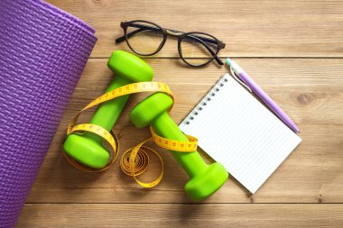 Halterler ahşap arka planda yeşil. Sağlıklı yaşam tarzı kavramı.