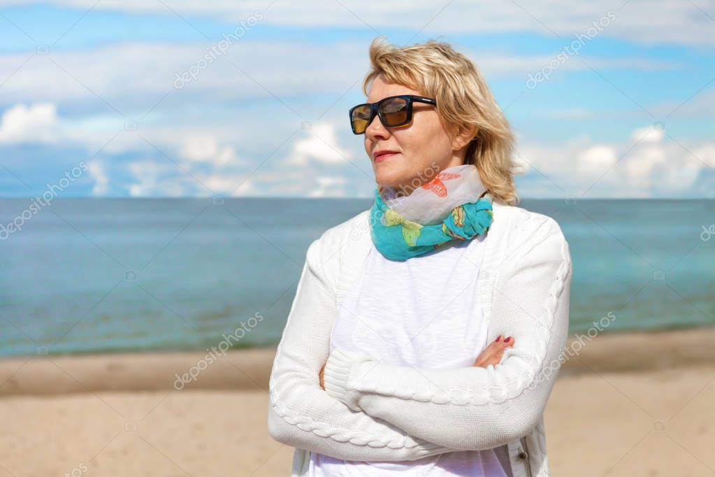 A woman walks in the open air by the beach river.