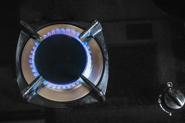 На черной газовой плите на кухне горит голубой огонь. — стоковое фото