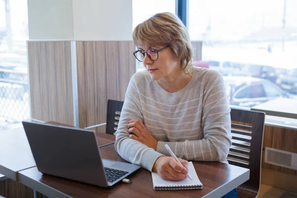 Mulher de meia-idade negócios no local de trabalho no café, escritório, ela está trabalhando em seu laptop . — Fotografia de Stock