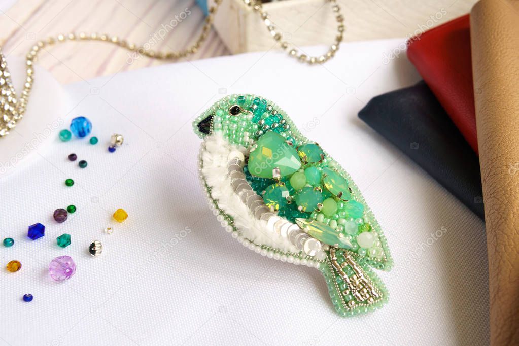 Brooch made of handmade colored beads on the background