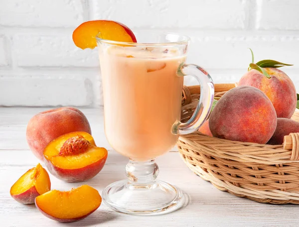 Sweet ripe juicy peaches with green leaves on a wooden background