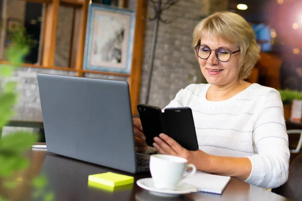 Uma mulher com um laptop trabalha em um café no escritório, ela é freelancer e empresária. — Fotografia de Stock