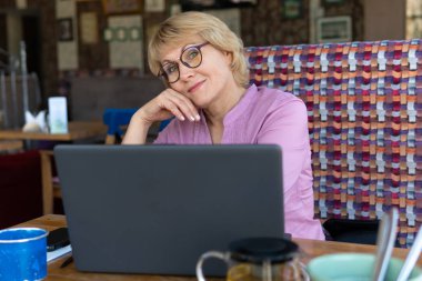 Ofisteki bir kafede dizüstü bilgisayarı olan kadın serbest çalışıyor..
