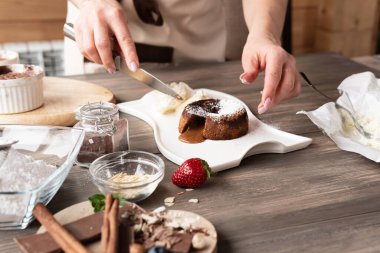 Odaklanmayı seç. Kek tatlısı için malzemeler sevecen ve koyu ahşap arka planda. Kadın eli turta yapar..