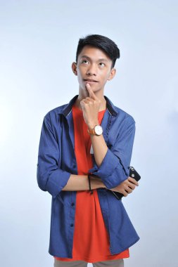 Yakışıklı genç öğrenci asyalı çocuk elini çene üzerinde que düşünme