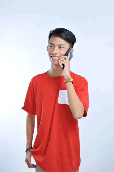 Porträtt av en ung student asiatisk man pratar på mobiltelefon, s — Stockfoto