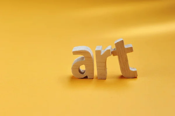 Word ART sculpté dans un support en bois sur fond jaune pour votre desi — Photo