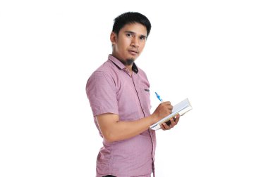 Asyalı erkek pembe t-shirt ile günlüğüne yazma