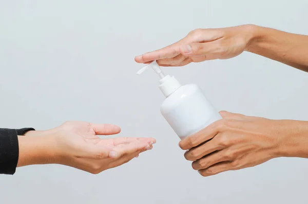 Okul öğretmeni okula girmeden önce alkol spreyi ya da el dezenfektanı kullanıyor COVID-19 salgını sırasında el hijyenine bakıyor.