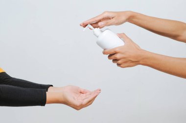Okul öğretmeni okula girmeden önce alkol spreyi ya da el dezenfektanı kullanıyor COVID-19 salgını sırasında el hijyenine bakıyor.