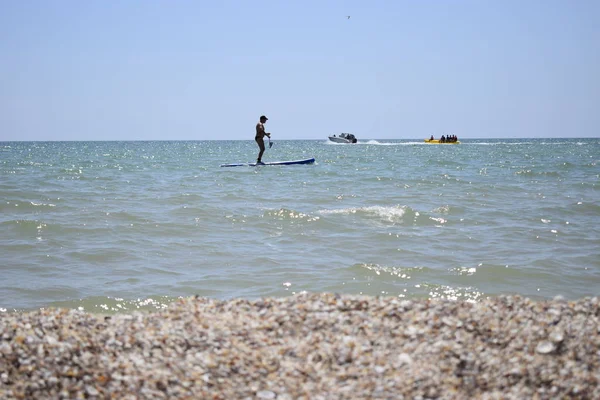 Surfeur avec planche à pagaie attrapant la vague. Planche à pagaie en eau libre . — Photo
