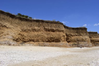 Çarpıcı kumlu plaj ziyaret. Büyük kırmızı kayalar ve kayalıklar ile mavi gökyüzü