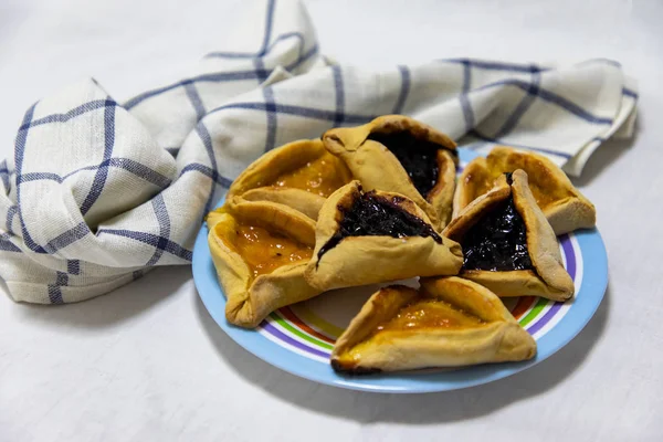 Hamantash Purim biscoitos de mirtilo e geléia de damasco em pla colorido — Fotografia de Stock