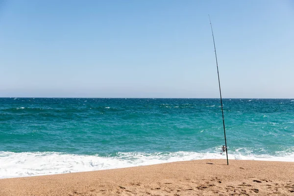 Vara de pesca na praia no dia ensolarado — Fotografia de Stock