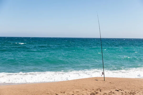 Vara de pesca na praia no dia ensolarado — Fotografia de Stock