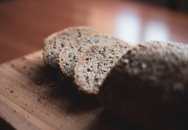 Evde ahşap kesme tahtası üzerinde dilimlenmiş çok tahıllı ev yapımı ekmek