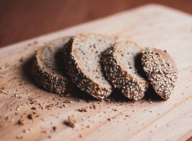 Evde ahşap kesme tahtası üzerinde dilimlenmiş çok tahıllı ev yapımı ekmek