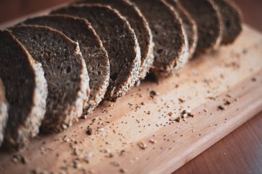 Evde ahşap kesme tahtası üzerinde dilimlenmiş çok tahıllı ev yapımı ekmek