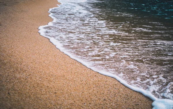 Primer plano de las olas marinas en la arena de la playa — Foto de Stock