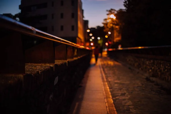 Auf der Brücke bei Nacht mit verschwommenen Menschen und Lichtern im Hintergrund — Stockfoto